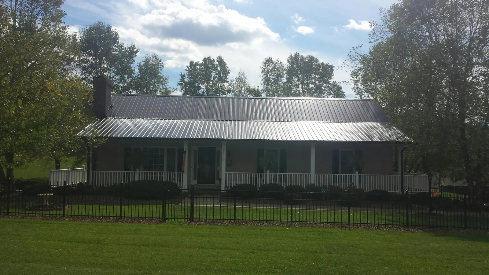Gray metal roof on a brick ranch with a full width front porch — Gutter Guard Installation work by our crew in Bloomfield Hills