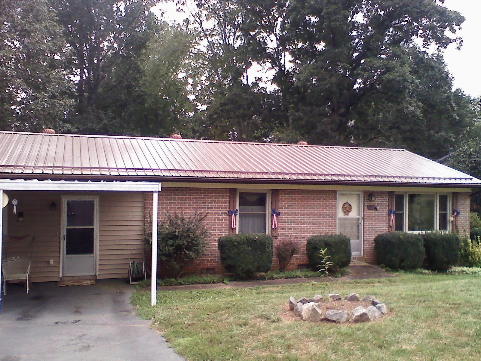 Bronze metal roof and carport on a brick ranch home — Roof Repair work by our crew in Bloomfield Hills
